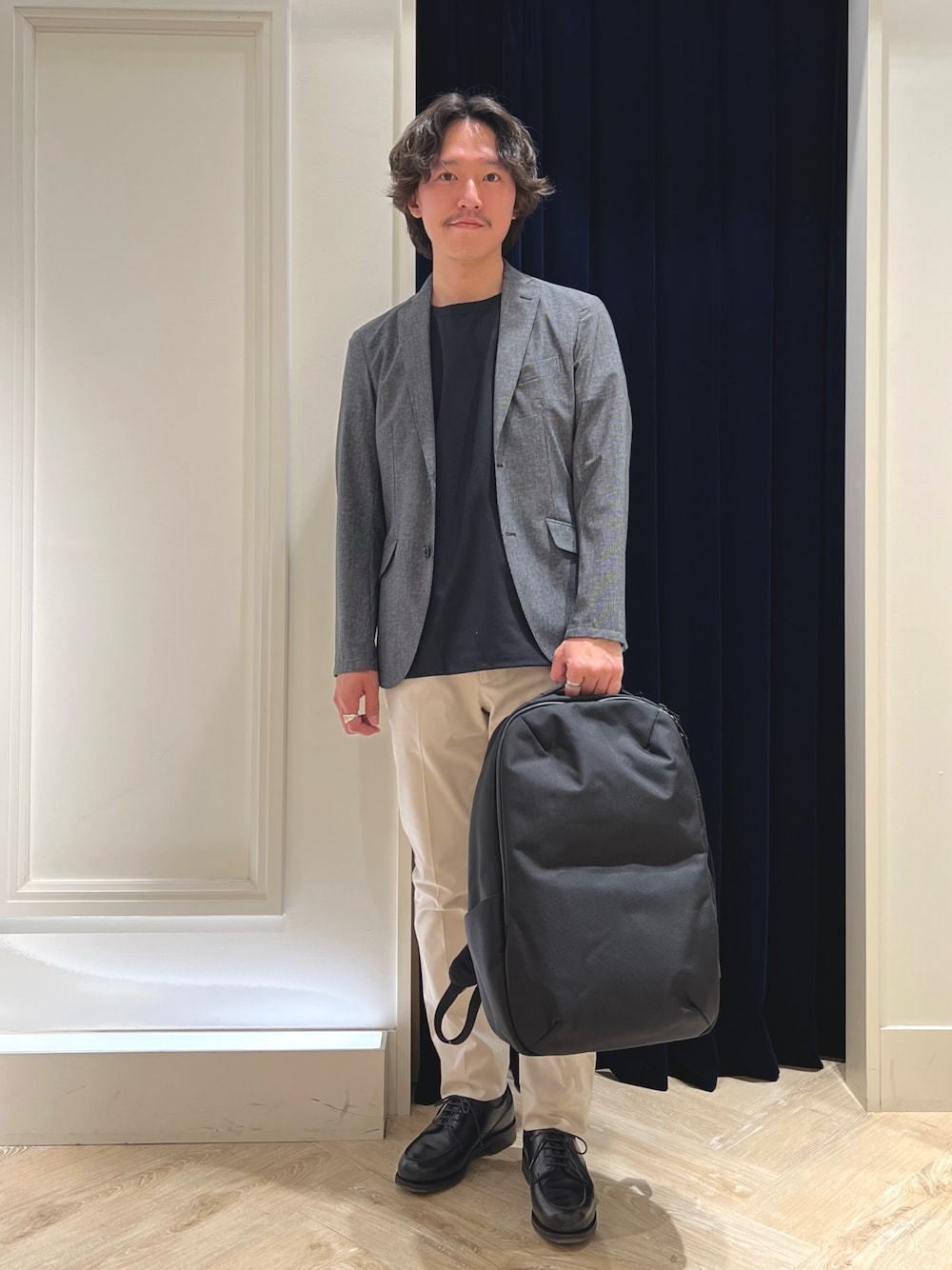 グレー系のテーラードジャケット、ブラック系のTシャツ/カットソー、ホワイト系のチノパンツを着用したメンズの春コーディネートの1枚目の写真