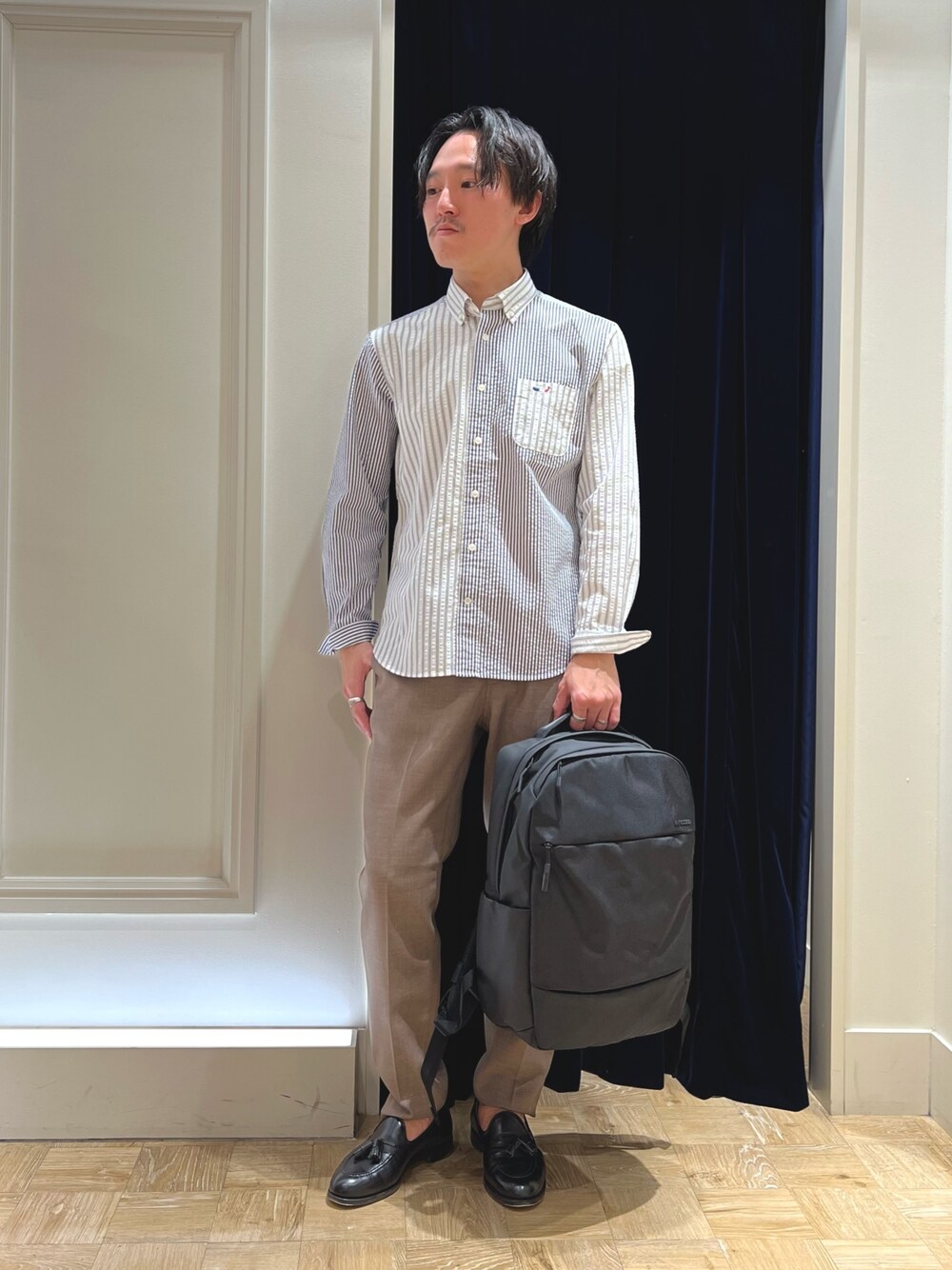 ホワイト系のシャツ/ブラウス、ベージュ系のその他パンツ、ブラック系のバックパック/リュックを着用したメンズの冬コーディネートの1枚目の写真