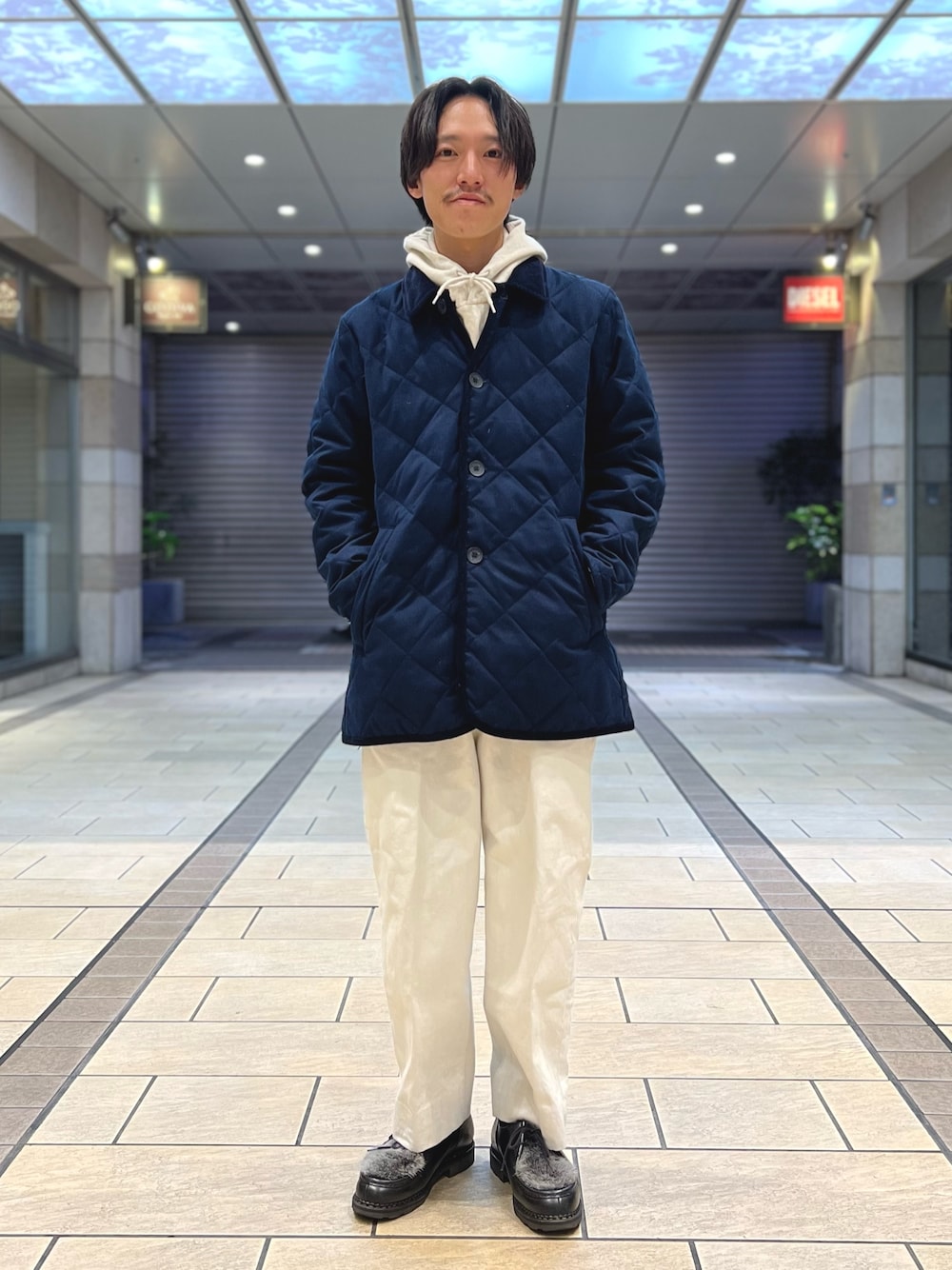 ホワイト系のパーカー、ブルー系のダウンジャケット/コート、ブラック系のシューズを着用したメンズの冬コーディネートの1枚目の写真