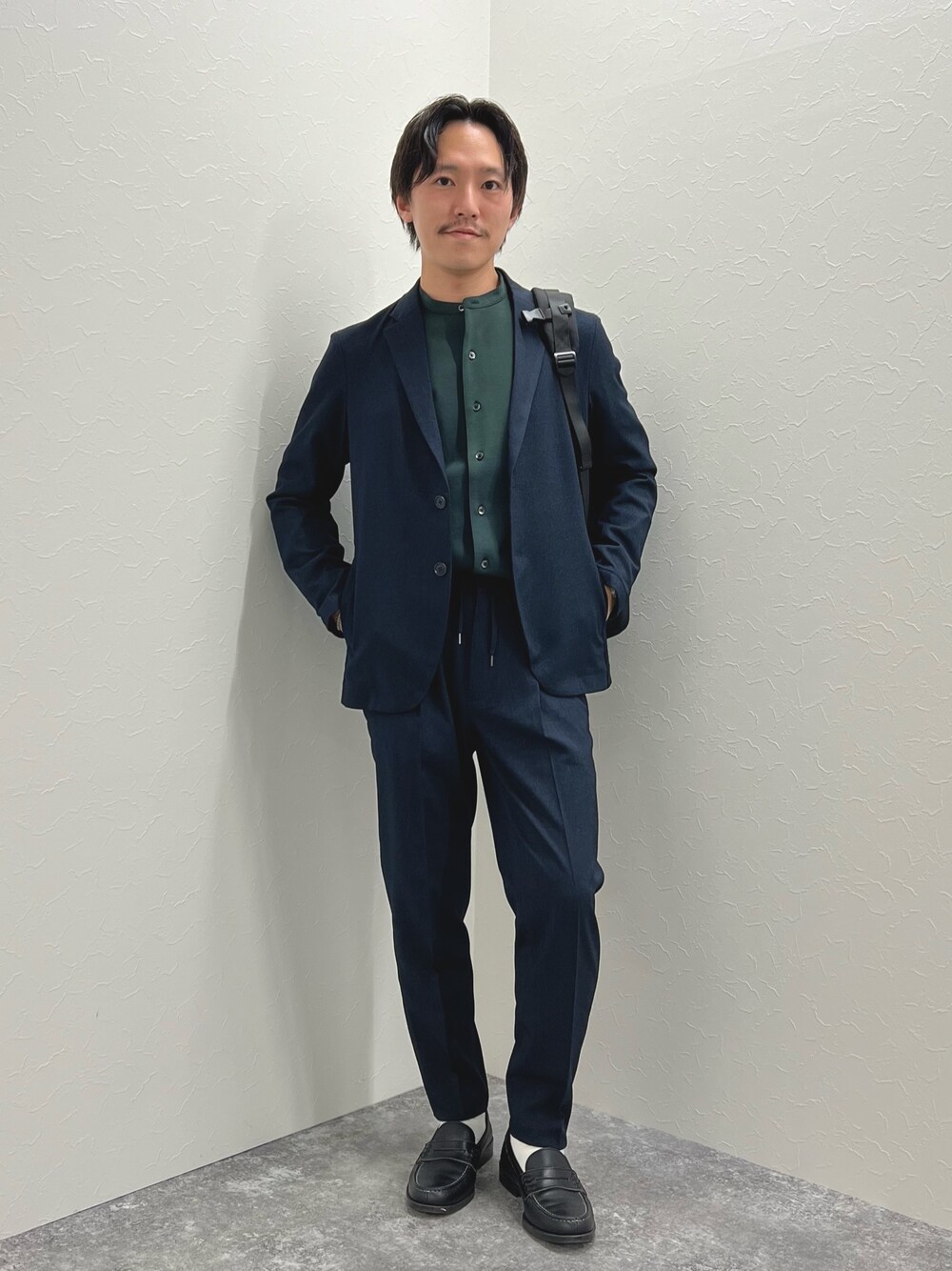 ブルー系のテーラードジャケット、ブルー系のその他パンツ、ブラック系のバックパック/リュックを着用したメンズの秋コーディネートの1枚目の写真