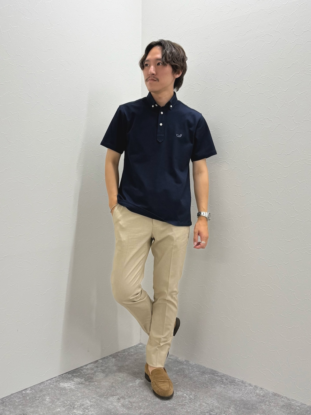 ブルー系のポロシャツ、ベージュ系のチノパンツ、イエロー系のローファーを着用したメンズの夏コーディネートの1枚目の写真