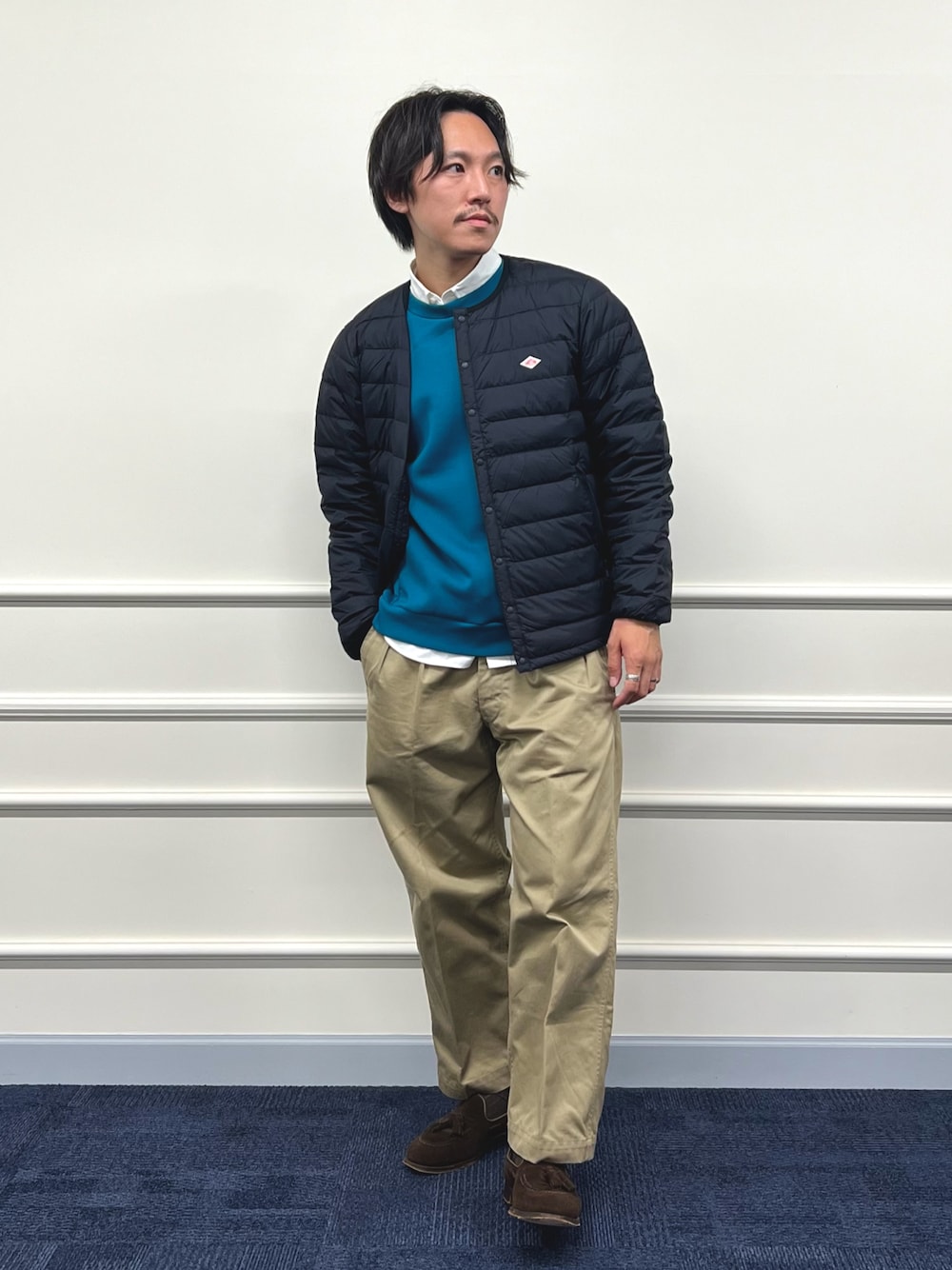 ブラック系のダウンジャケット/コート、ブルー系のスウェット、ホワイト系のシャツ/ブラウスを着用したメンズの秋コーディネートの1枚目の写真
