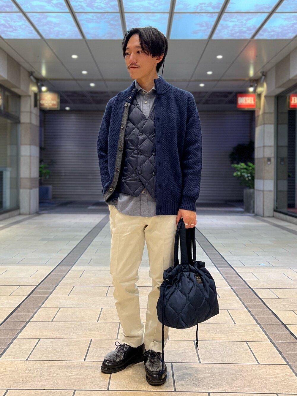 「ファッションを楽しもう、レイヤードスタイル、お出かけコーデ、きれいめカジュアル、トートバッグ、ローファー、ニット、カジュアルコーデ、休日コーデ、秋冬コーデ、冬コーデ、ダウン、ダウンベスト、カーディガン」｜「TAIONの【TAION/タイオン】MILITARY DOWN TOTE BAG M（トートバッグ、ブルー系）」を使った、nishiokaさん（メンズ・169cm）の秋コーディネートの1枚目の写真