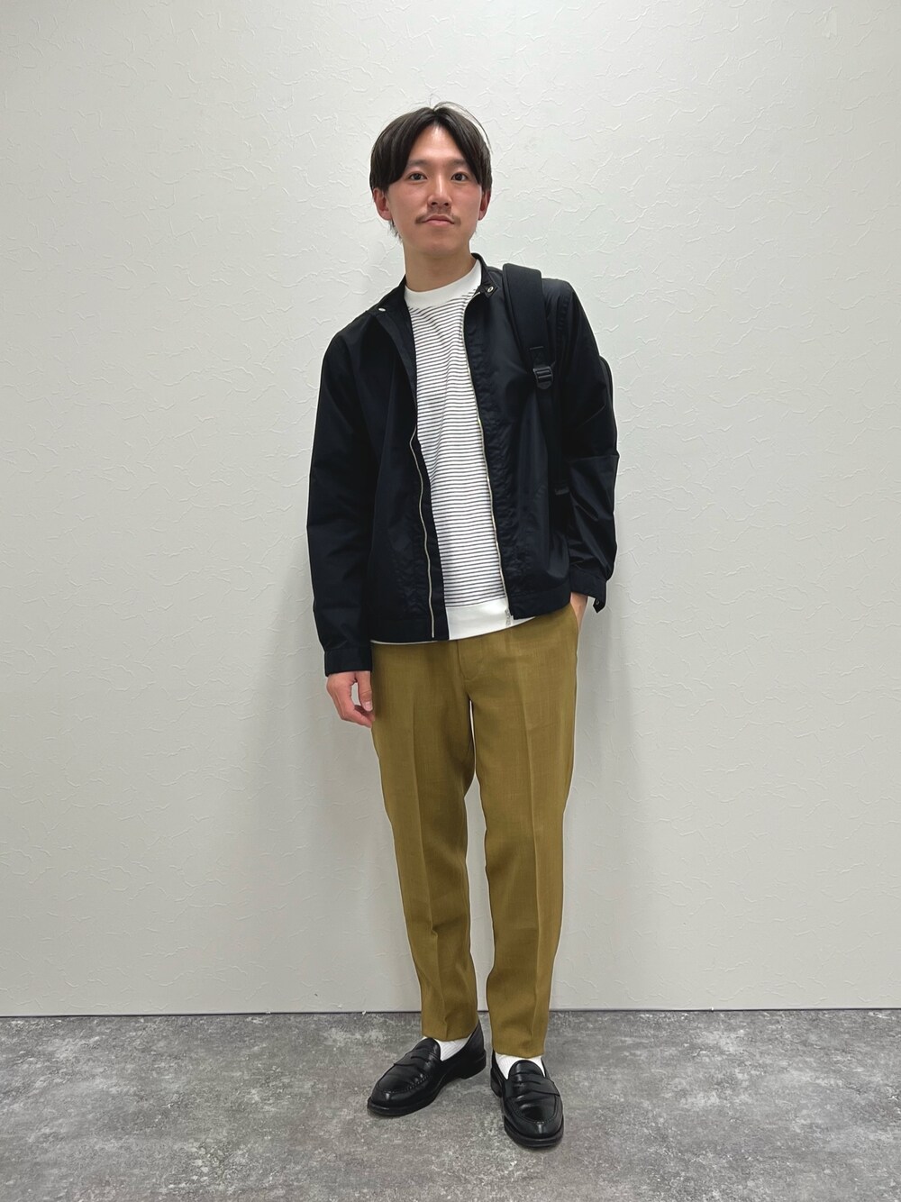 ブラック系のブルゾン、ベージュ系のその他パンツ、ブラック系のサンダルを着用したメンズの春コーディネートの1枚目の写真