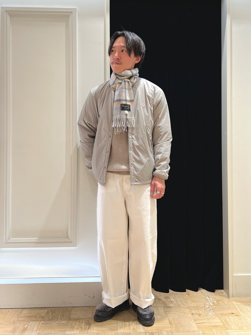 グレー系のブルゾン、ブラック系のシューズ、グレー系のマフラーを着用したメンズの冬コーディネートの1枚目の写真