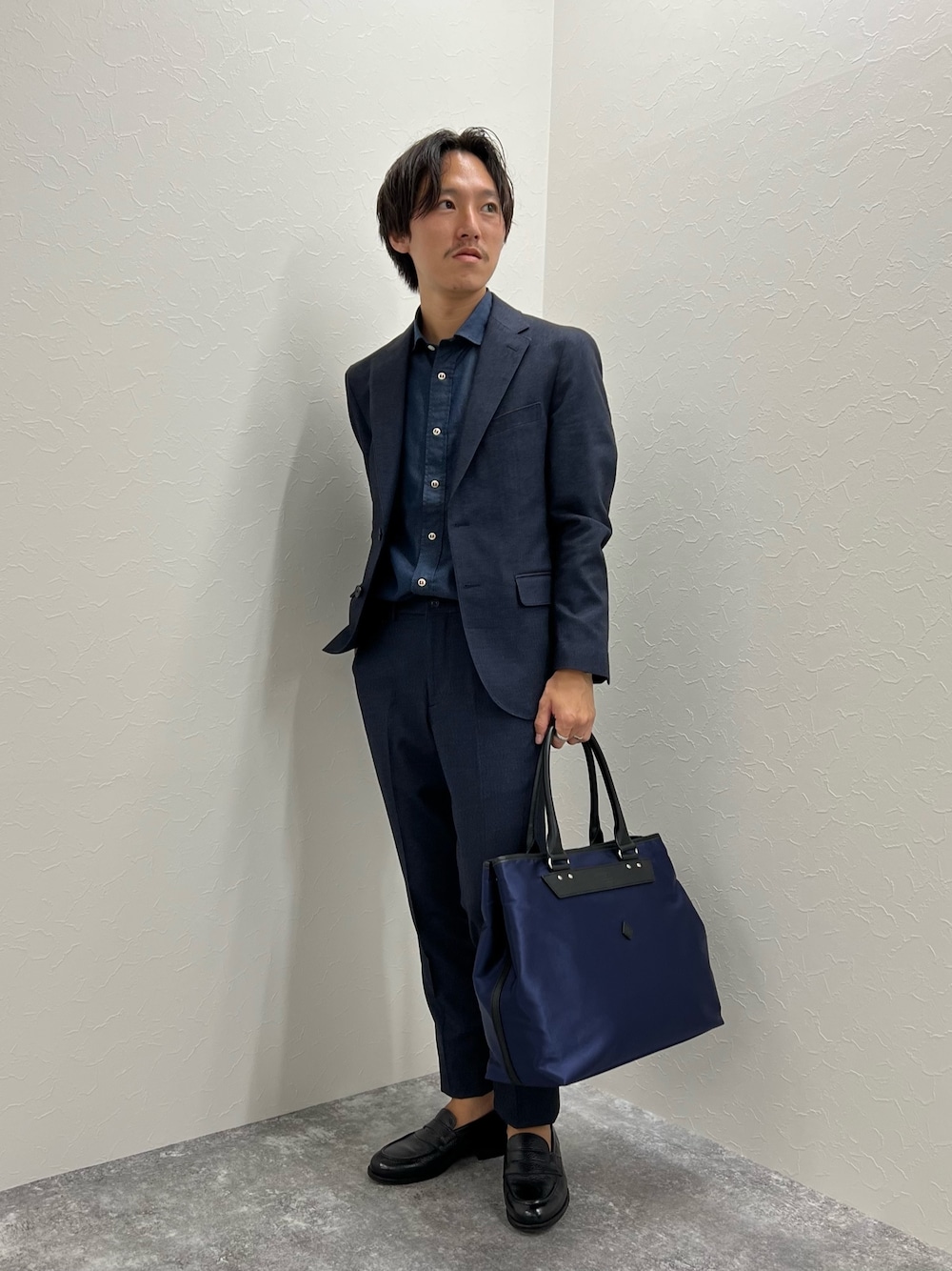 ブルー系のテーラードジャケット、ブルー系のその他パンツ、ブルー系のトートバッグを着用したメンズの秋コーディネートの1枚目の写真