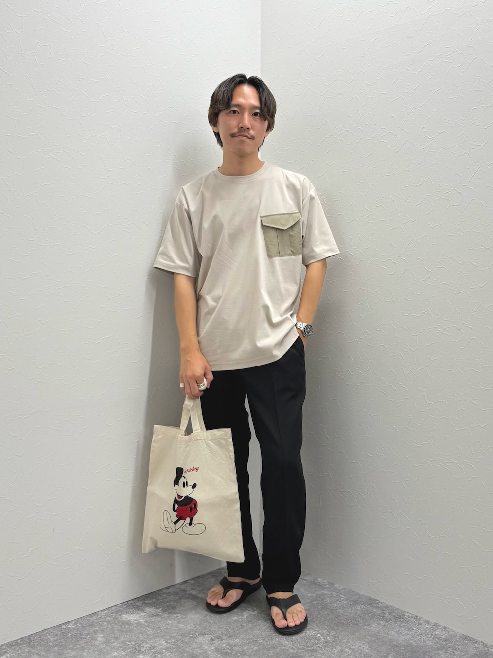ベージュ系のTシャツ/カットソー、ホワイト系のトートバッグ、ブラック系のその他パンツを着用したメンズの夏コーディネートの1枚目の写真