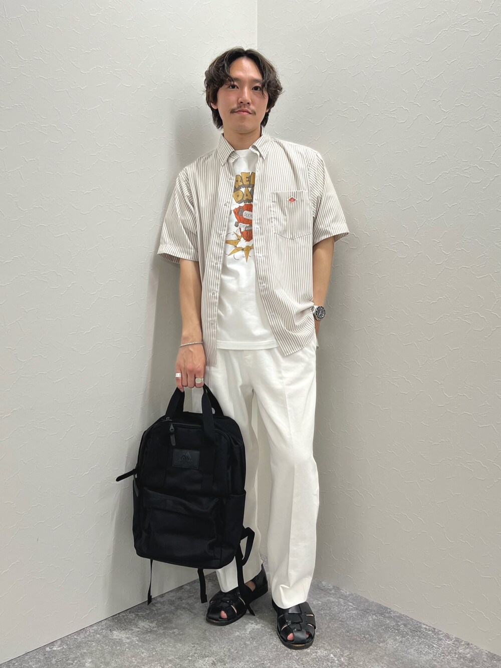 ホワイト系のTシャツ/カットソー、ブラック系のバックパック/リュック、ホワイト系のデニムパンツを着用したメンズの春コーディネートの1枚目の写真