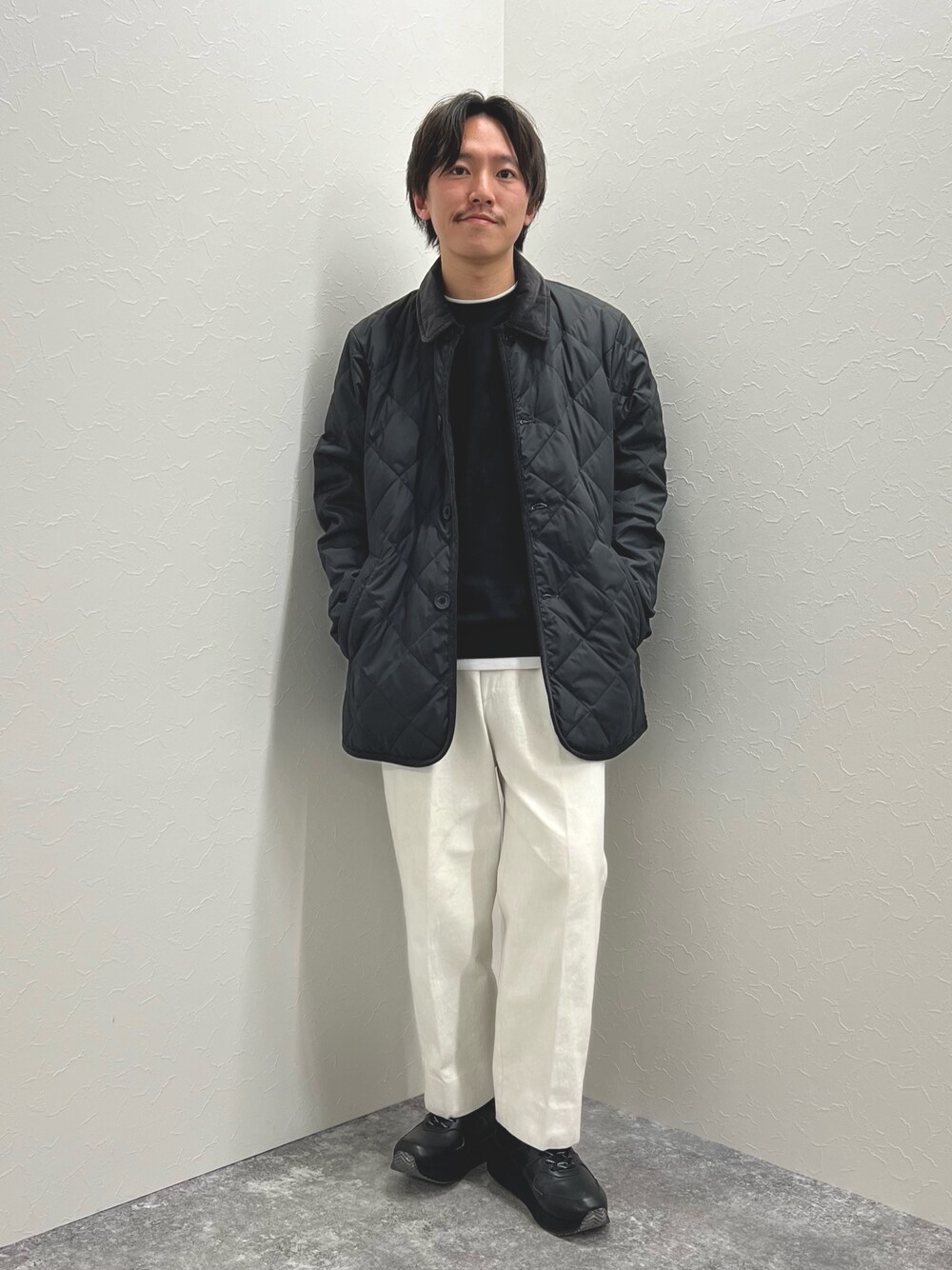 ブラック系のダウンジャケット/コート、ブラック系のTシャツ/カットソー、ブラック系のスニーカーを着用したメンズの秋コーディネートの1枚目の写真