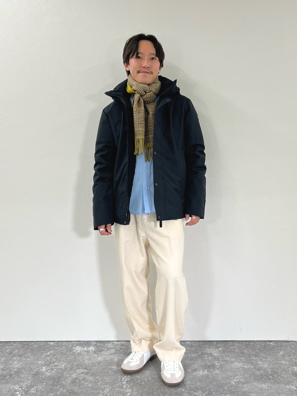 ブラック系のダウンジャケット/コート、ブルー系のシャツ/ブラウス、イエロー系のマフラーを着用したメンズの冬コーディネートの1枚目の写真