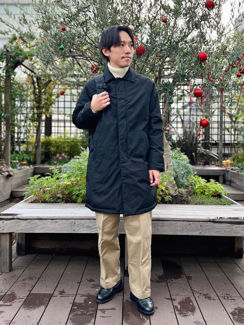 「冬アウター、休日スタイル、ロングコート、お出かけコーデ、きれいめカジュアル、タートルネック、ローファー、秋冬コーデ、冬、シンプルスタイル、モノトーン、ダウン、バックパック、ニット、ダウンジャケット」｜「TAIONの【TAION/タイオン】別注ダウンステンカラーコート（ダウンジャケット/コート、ブラック系）」を使った、nishiokaさん（メンズ・169cm）の冬コーディネートの1枚目の写真