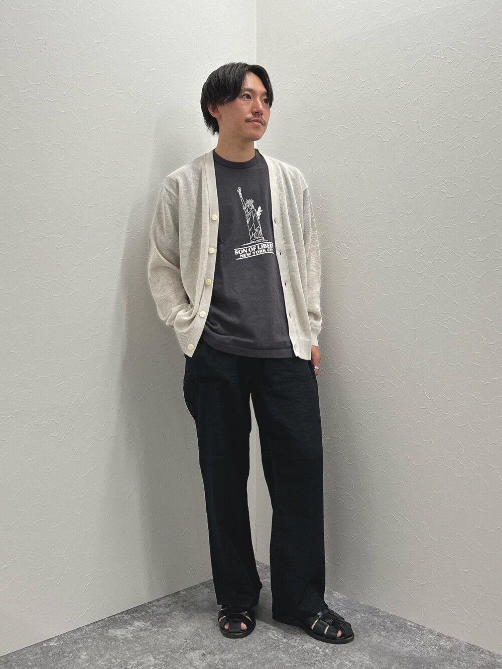 ベージュ系のカーディガン/ボレロ、グレー系のTシャツ/カットソー、ブラック系のサンダルを着用したメンズの春コーディネートの1枚目の写真