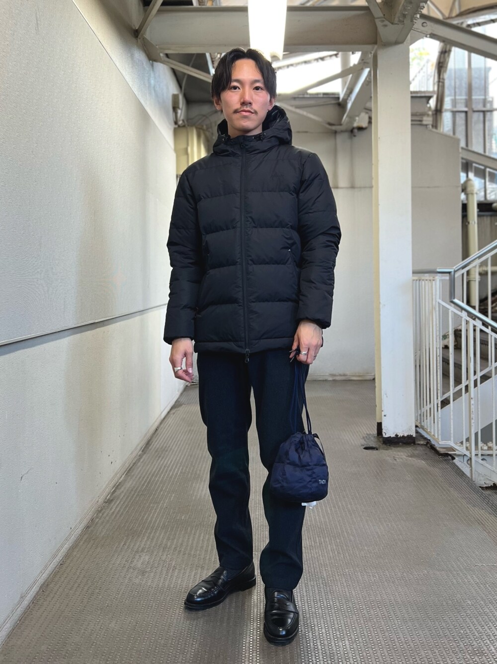 ブラック系のダウンジャケット/コート、ブルー系のショルダーバッグ、ブルー系のその他パンツを着用したメンズの冬コーディネートの1枚目の写真