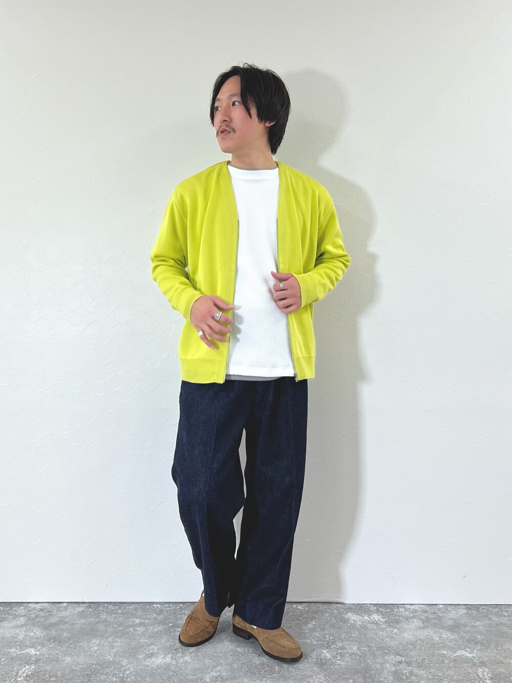 イエロー系のカーディガン/ボレロ、ホワイト系のTシャツ/カットソー、ブルー系のデニムパンツを着用したメンズの冬コーディネートの1枚目の写真