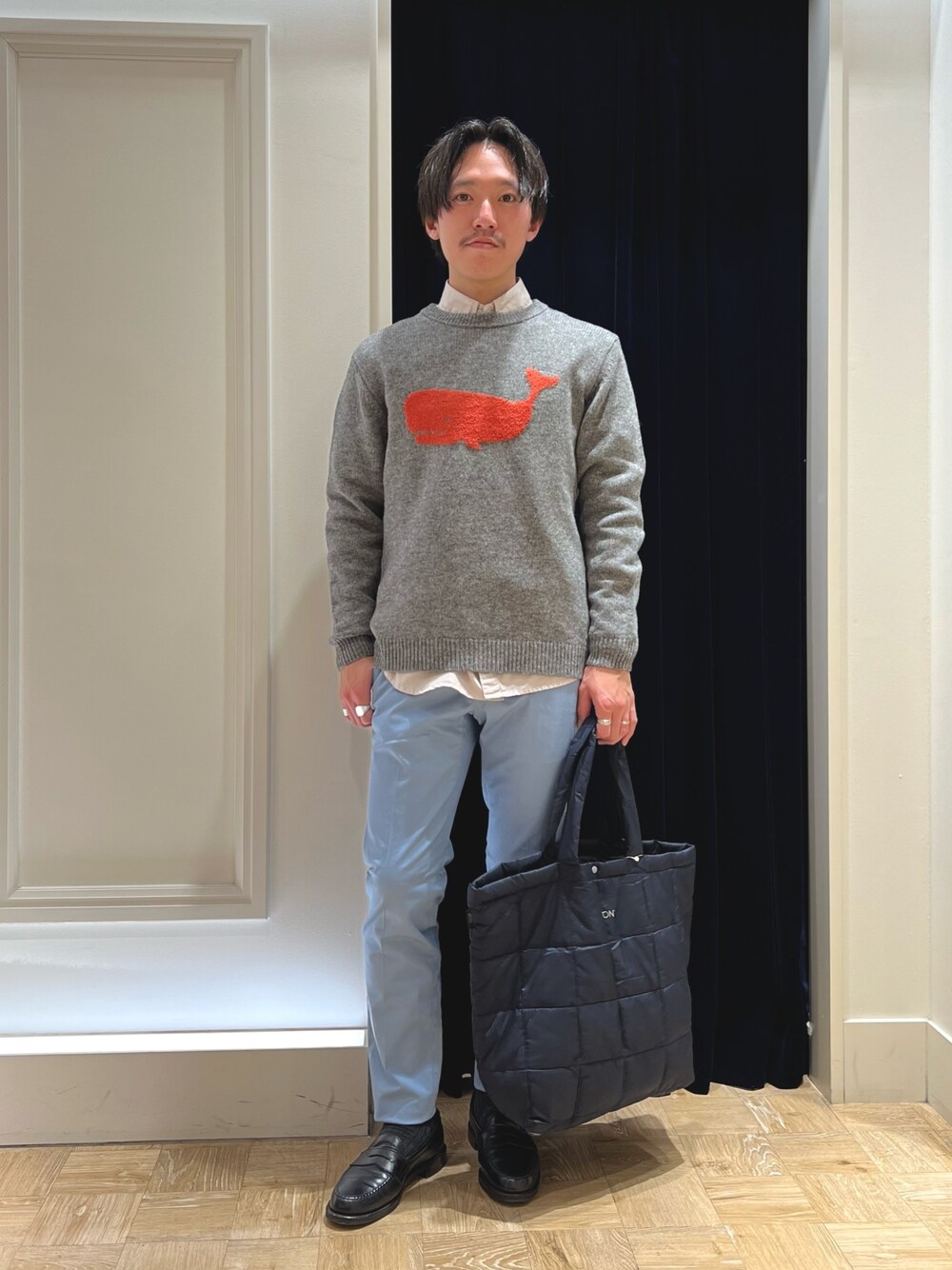 グレー系のニット/セーター、ベージュ系のシャツ/ブラウス、ブルー系のチノパンツを着用したメンズの冬コーディネートの1枚目の写真