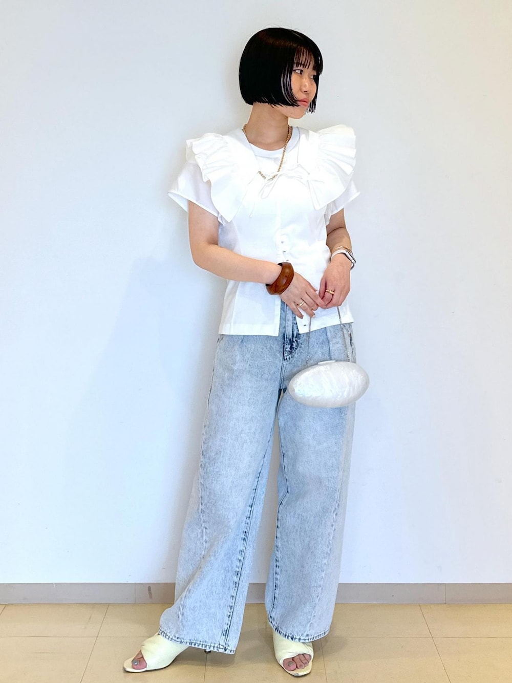 イエロー系のサンダル、ホワイト系のシャツ/ブラウス、ホワイト系のTシャツ/カットソーを着用したレディースの夏コーディネートの1枚目の写真