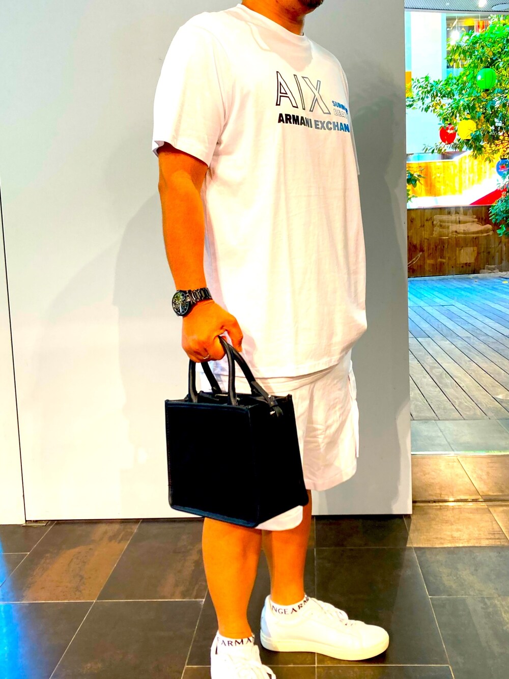 ホワイト系のTシャツ/カットソー、ホワイト系のその他パンツ、ブラック系のハンドバッグを着用したメンズの夏コーディネートの1枚目の写真
