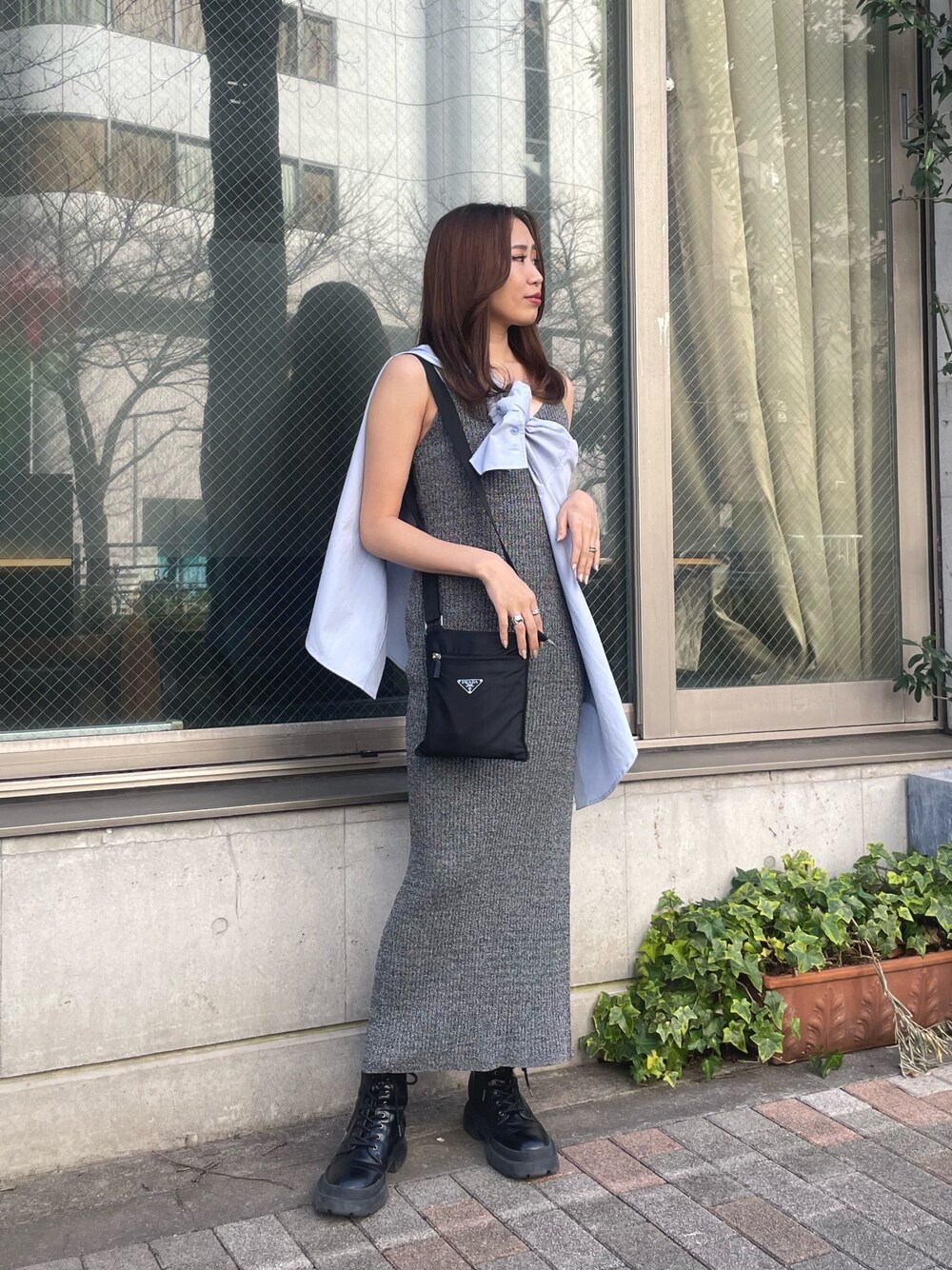 ブルー系のシャツ/ブラウス、ブラック系のワンピース、ブラック系のブーツを着用したレディースの春コーディネートの1枚目の写真