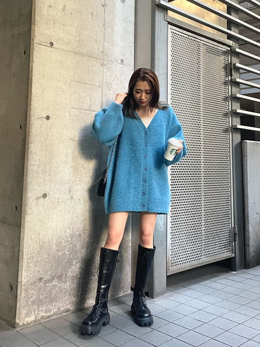 ブルー系のカーディガン/ボレロ、ブラック系のショルダーバッグ、ブラウン系のブーツを着用したレディースの秋コーディネートの1枚目の写真