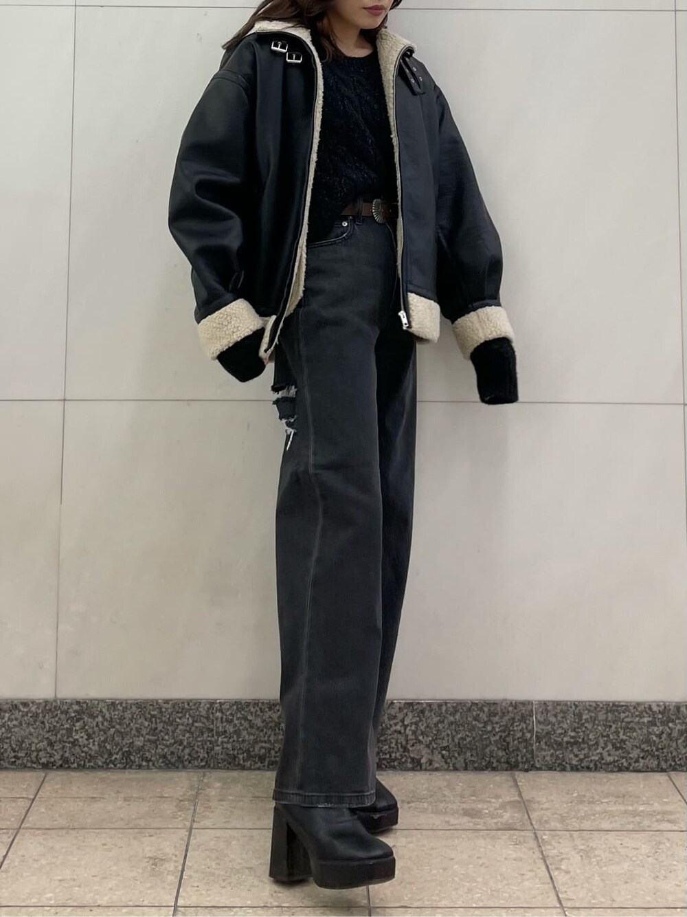 ブラック系のデニムパンツ、ブラック系のブルゾン、ブラック系のニット/セーターを着用したレディースの秋コーディネートの1枚目の写真