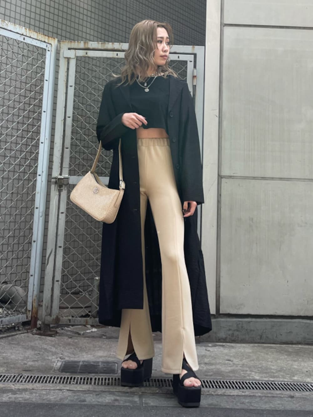 ホワイト系のショルダーバッグ、ブラック系のその他アウター、ブラック系のサンダルを着用したレディースの春コーディネートの1枚目の写真