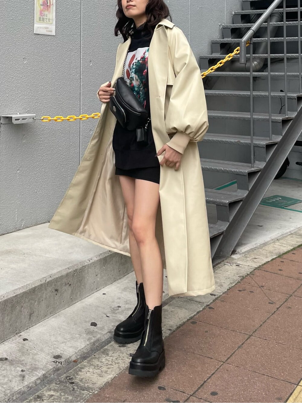 ブラック系のボディバッグ/ウエストポーチ、ブラック系のTシャツ/カットソー、ブラック系のブーツを着用したレディースの冬コーディネートの1枚目の写真