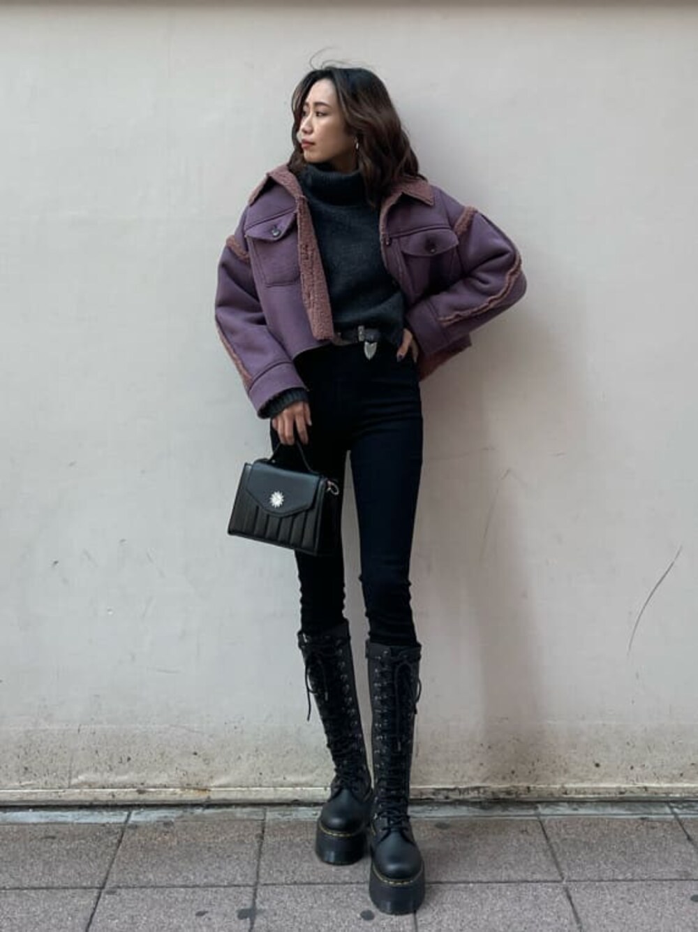 ブラック系のブーツ、パープル系のブルゾン、ブラック系のショルダーバッグを着用したレディースの冬コーディネートの1枚目の写真