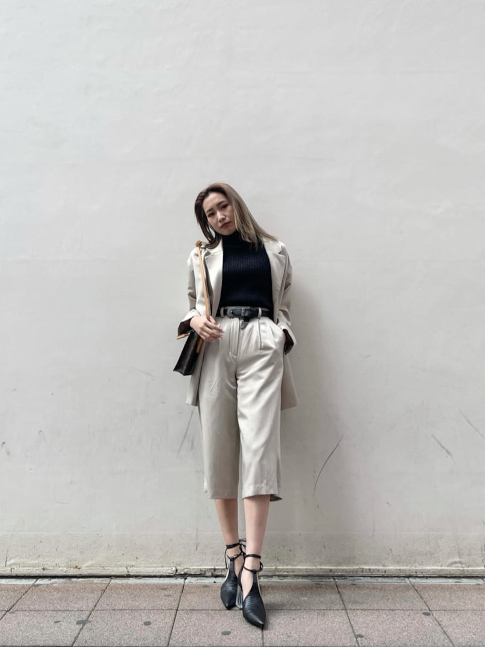 グレー系のテーラードジャケット、ブラック系のパンプス、ブラック系のタンクトップを着用したレディースの春コーディネートの1枚目の写真