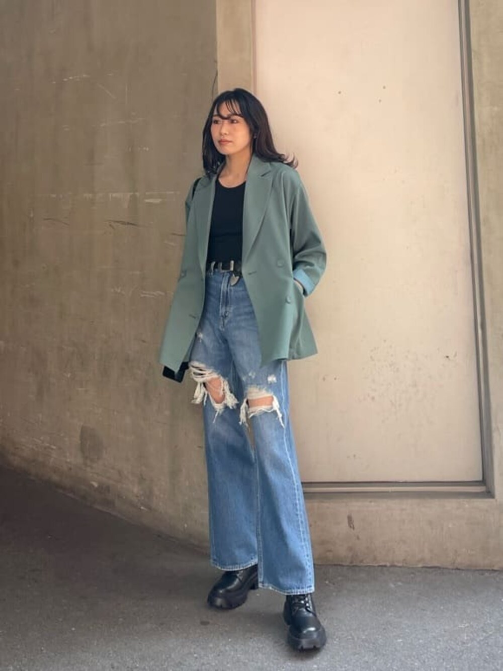 ブラック系のブーツ、ブルー系のデニムパンツ、ブラック系のTシャツ/カットソーを着用したレディースの春コーディネートの1枚目の写真