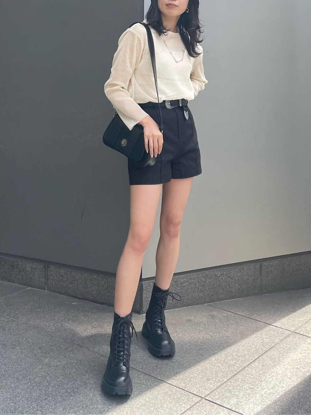 ブラック系のブーツ、ブラック系のその他パンツ、ホワイト系のTシャツ/カットソーを着用したレディースの春コーディネートの1枚目の写真