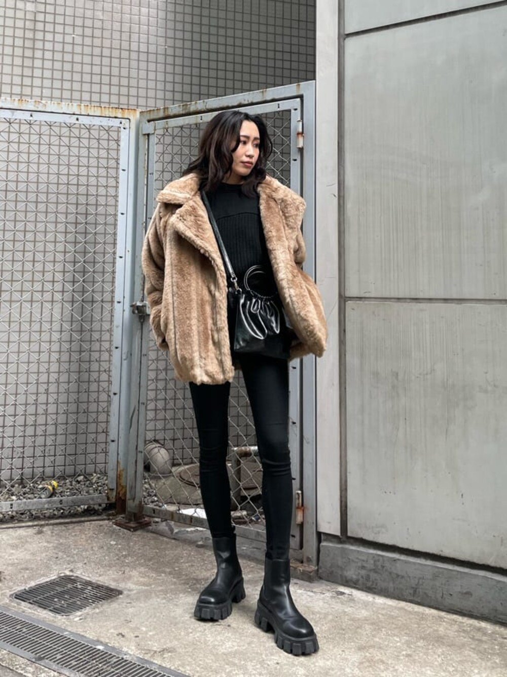 ブラック系のデニムパンツ、ベージュ系のその他アウター、ブラック系のブーツを着用したレディースの冬コーディネートの1枚目の写真
