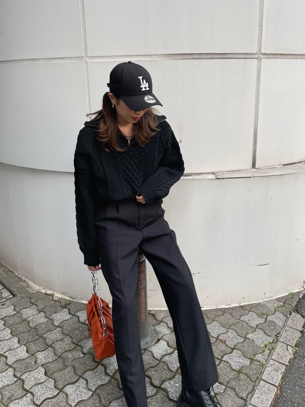 ブラック系のニット/セーター、ブラック系のスラックス、ブラック系のブーツを着用したレディースの冬コーディネートの1枚目の写真