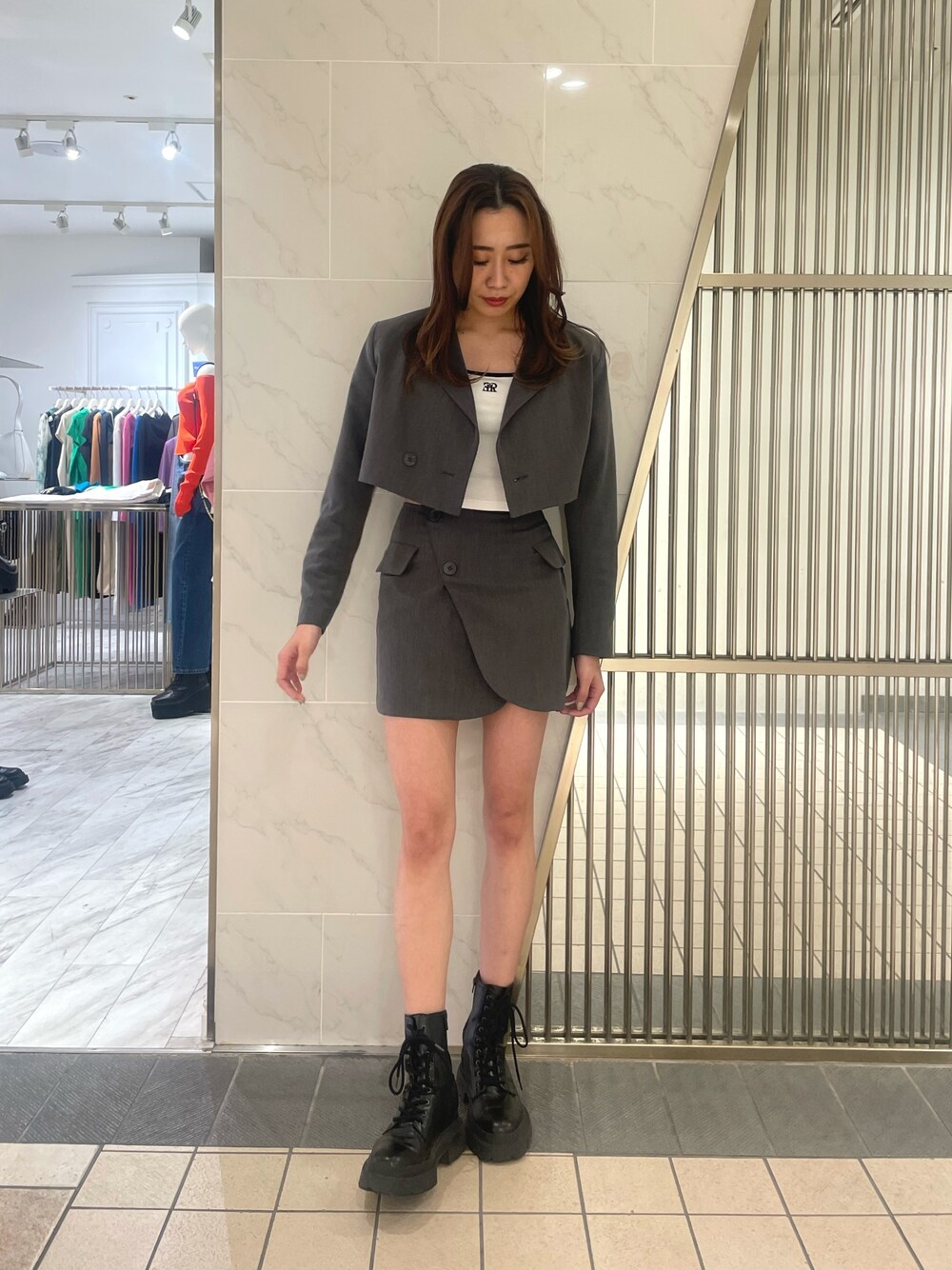 グレー系のテーラードジャケット、グレー系のスカート、ホワイト系のTシャツ/カットソーを着用したレディースの春コーディネートの1枚目の写真