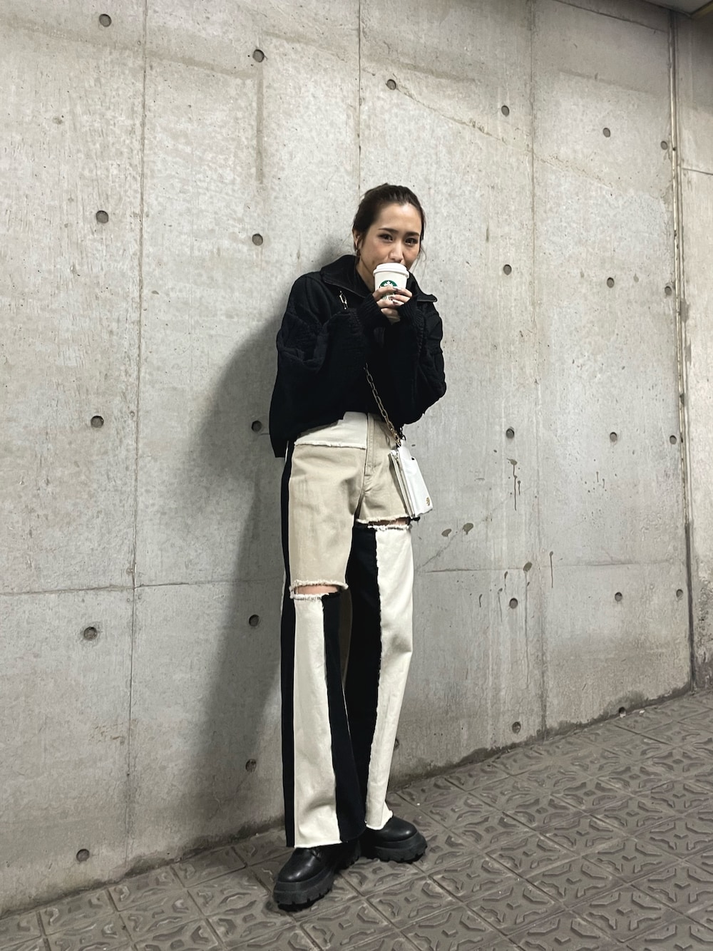 ブラック系のブーツ、ホワイト系のショルダーバッグ、ブラック系のニット/セーターを着用したレディースの冬コーディネートの1枚目の写真