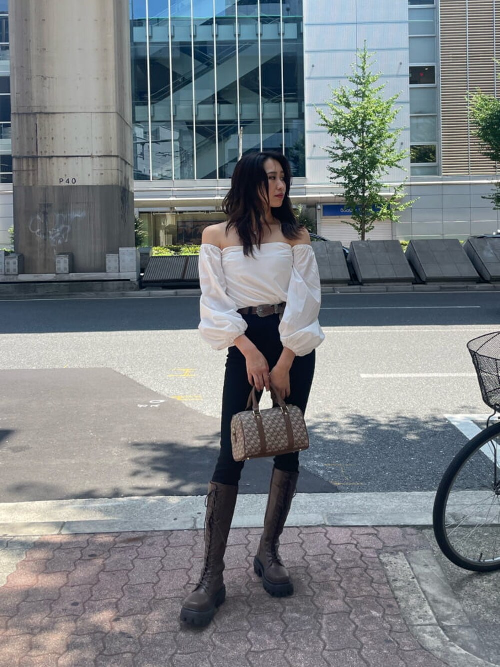 ブラウン系のブーツ、ブラウン系のボストンバッグ、ホワイト系のシャツ/ブラウスを着用したレディースの秋コーディネートの1枚目の写真