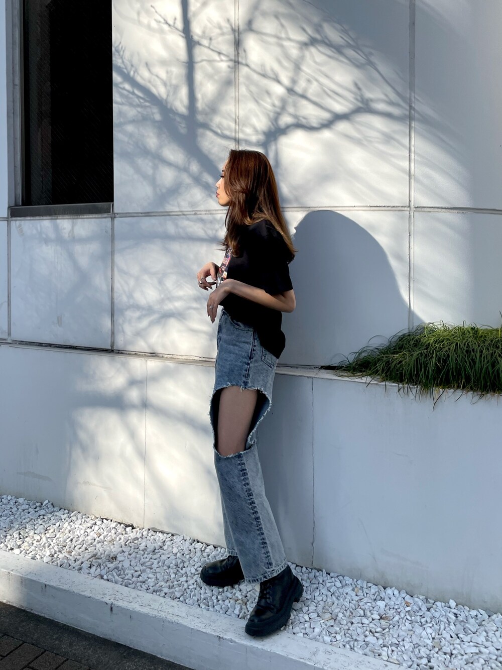ブラック系のTシャツ/カットソー、ブルー系のデニムパンツ、ブラック系のブーツを着用したレディースの春コーディネートの1枚目の写真