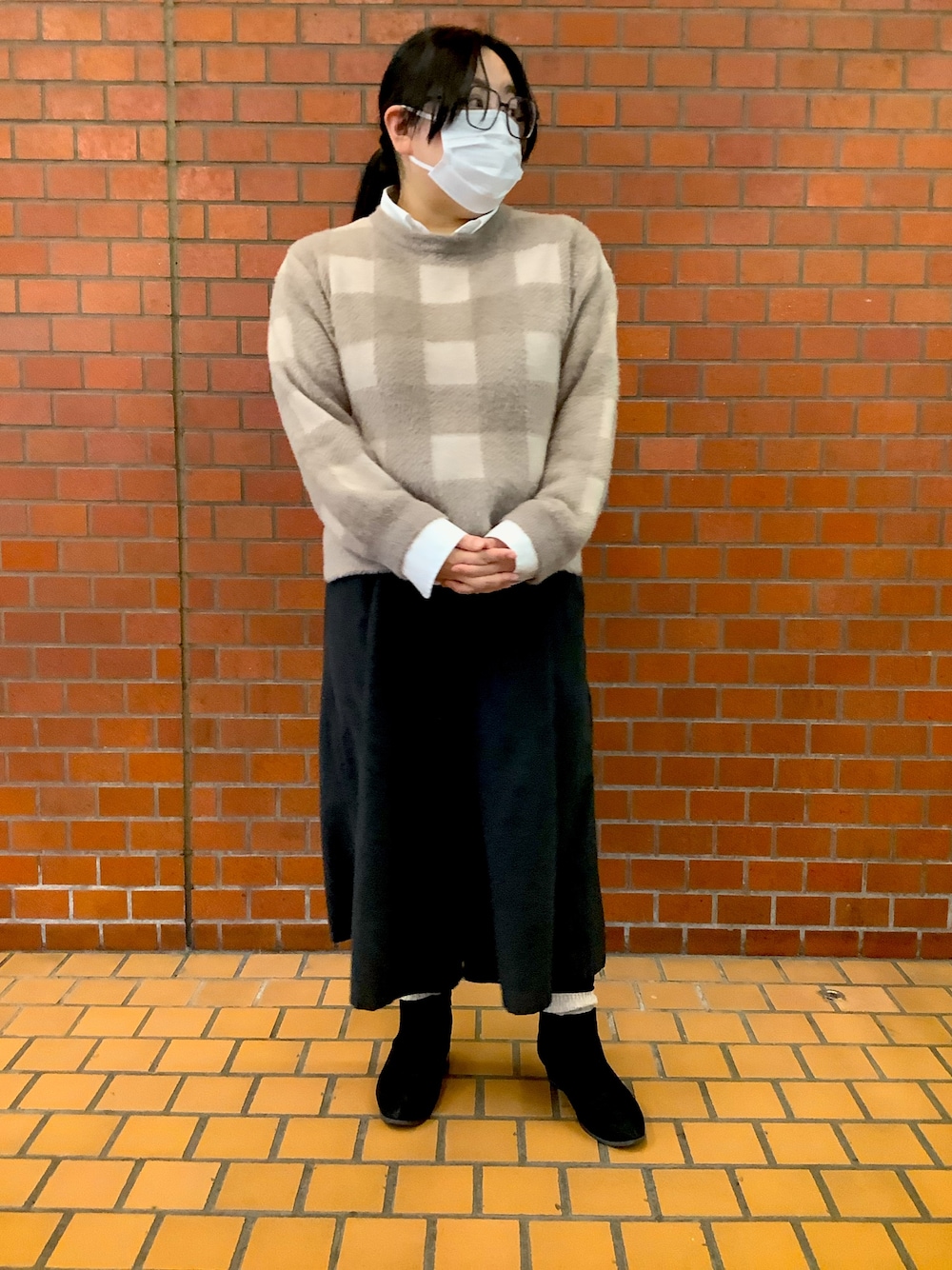 ブラウン系のニット/セーターを着用したレディースの冬コーディネートの1枚目の写真