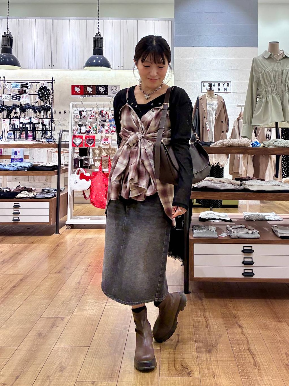 ブラウン系のブーツ、ブラック系のスカート、ブラック系のTシャツ/カットソーを着用したレディースの秋コーディネートの1枚目の写真