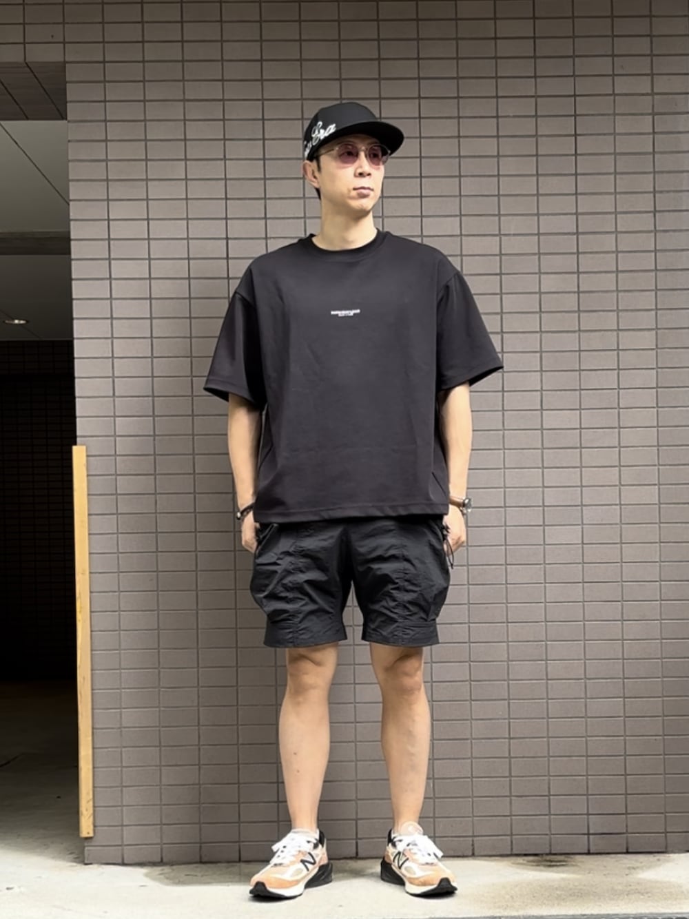 ブラック系のTシャツ/カットソー、ブラック系のその他パンツ、オレンジ系のスニーカーを着用したメンズの夏コーディネートの1枚目の写真