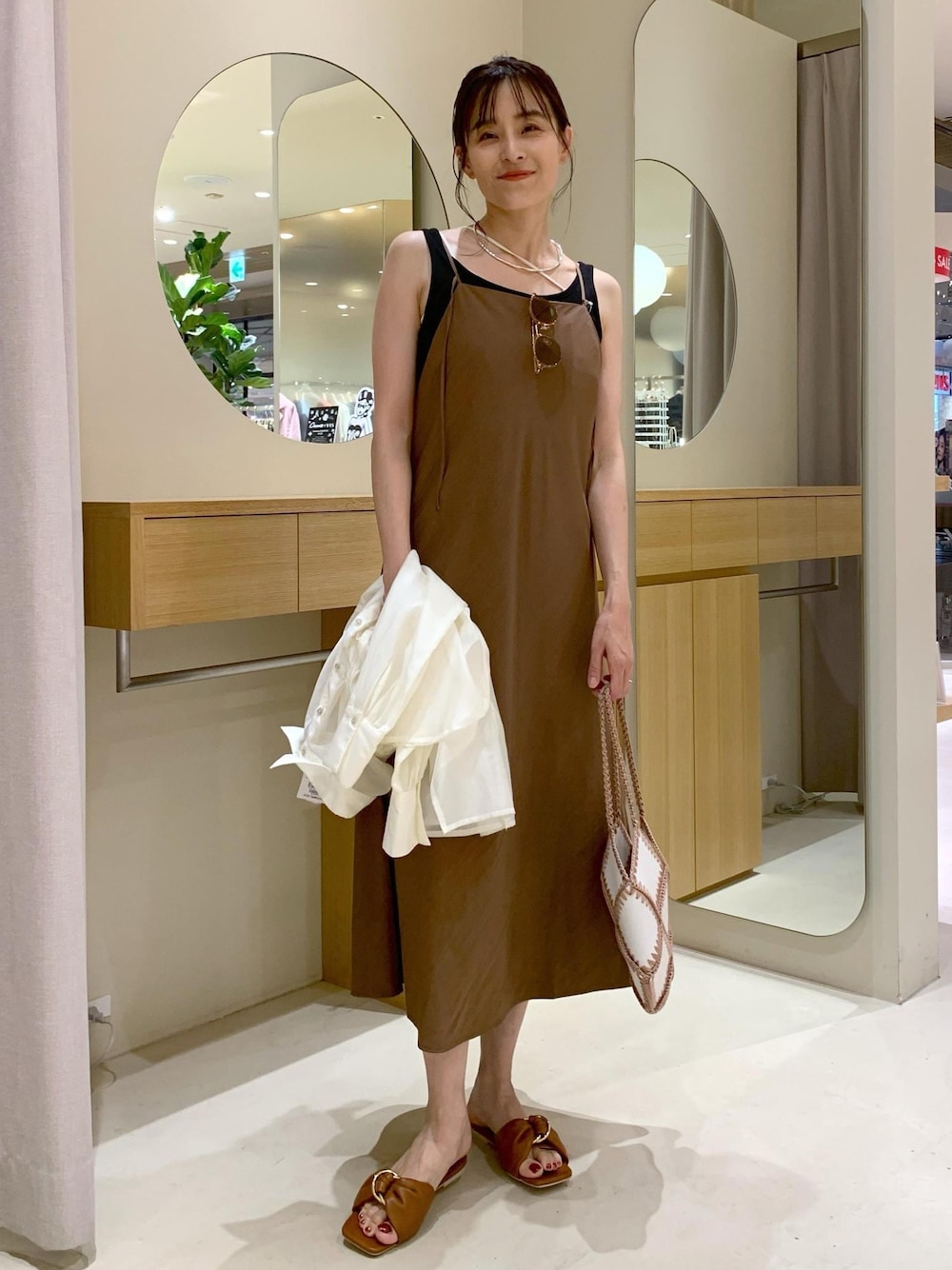 イエロー系のサンダル、ブラウン系のワンピース、ブラック系のタンクトップを着用したレディースの夏コーディネートの1枚目の写真