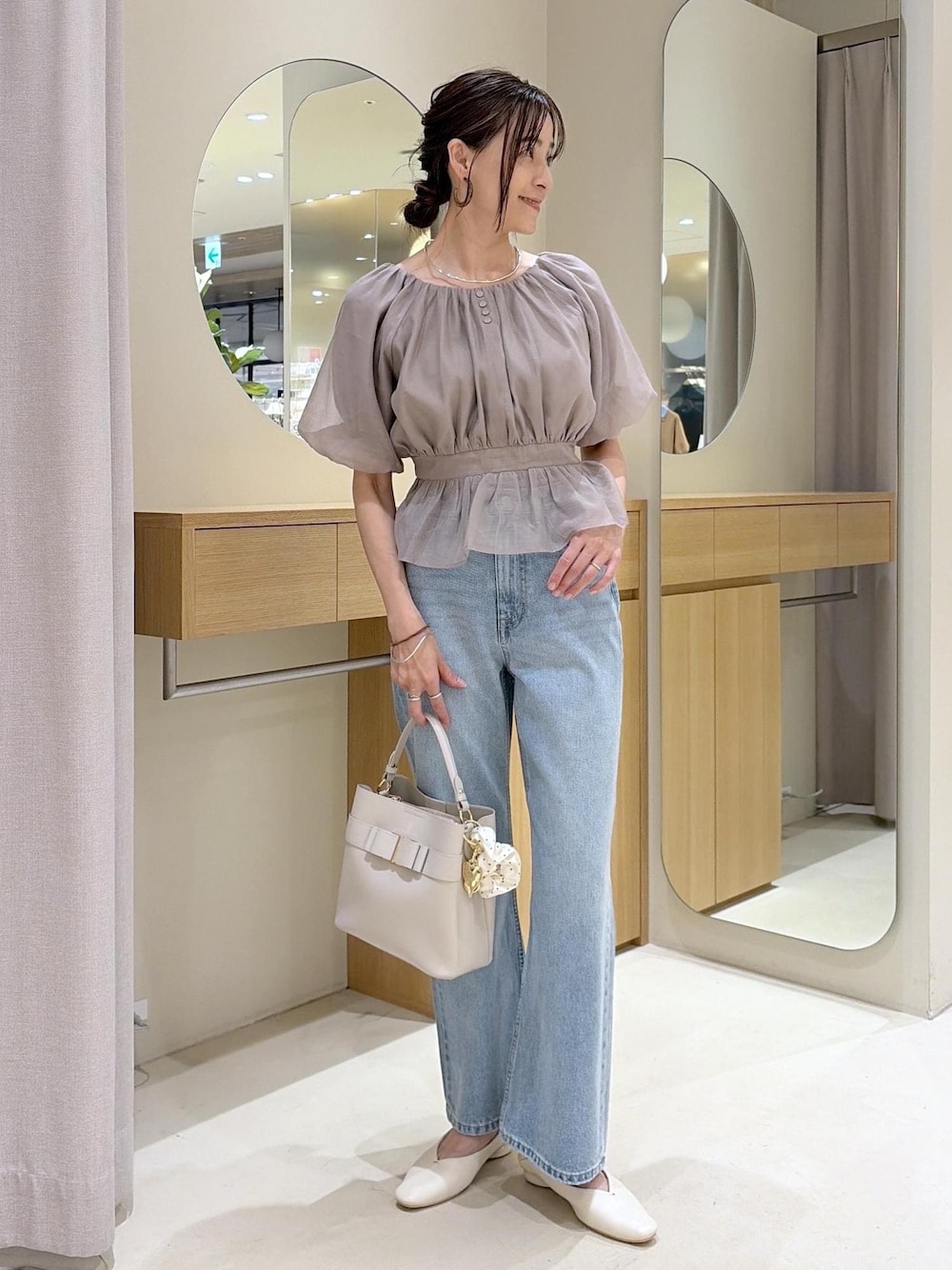 ホワイト系のパンプス、ベージュ系のシャツ/ブラウス、ブルー系のデニムパンツを着用したレディースの夏コーディネートの1枚目の写真
