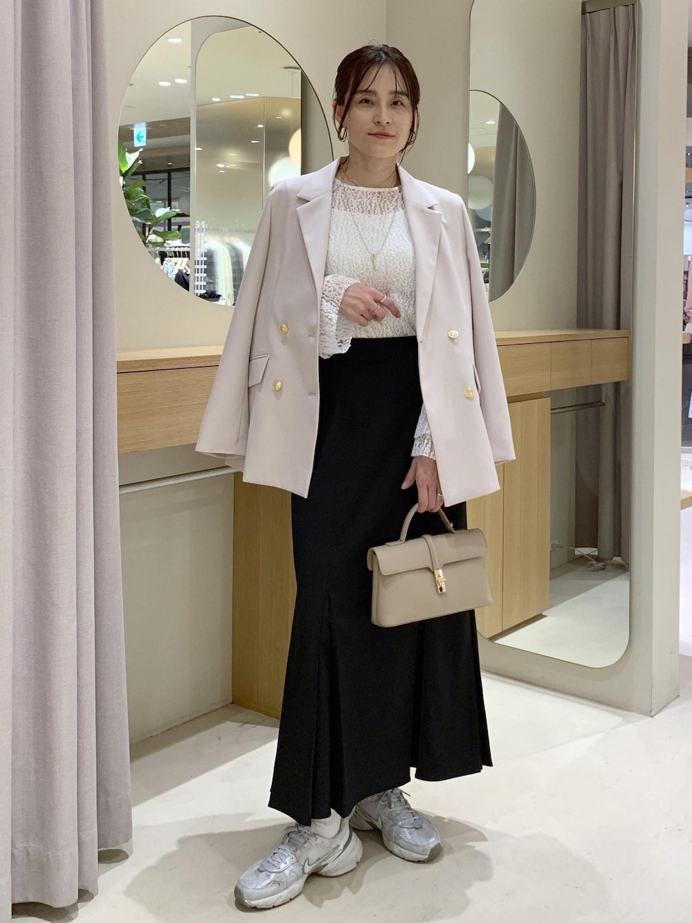 ブラック系のスカート、ホワイト系のTシャツ/カットソー、ベージュ系のテーラードジャケットを着用したレディースの冬コーディネートの1枚目の写真