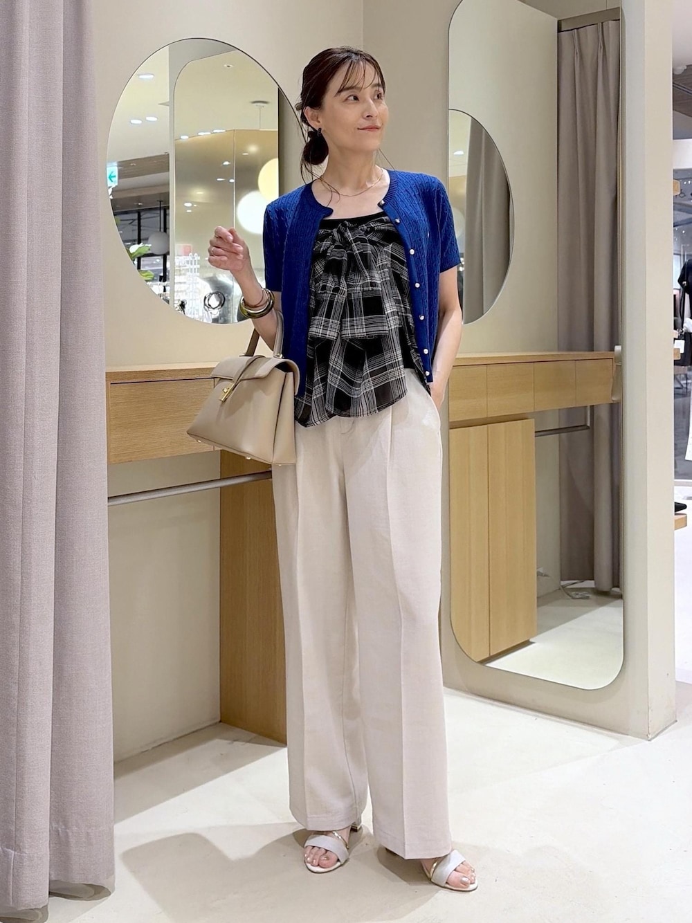 ベージュ系のハンドバッグ、ホワイト系のその他パンツ、ブラック系のシャツ/ブラウスを着用したレディースの夏コーディネートの1枚目の写真