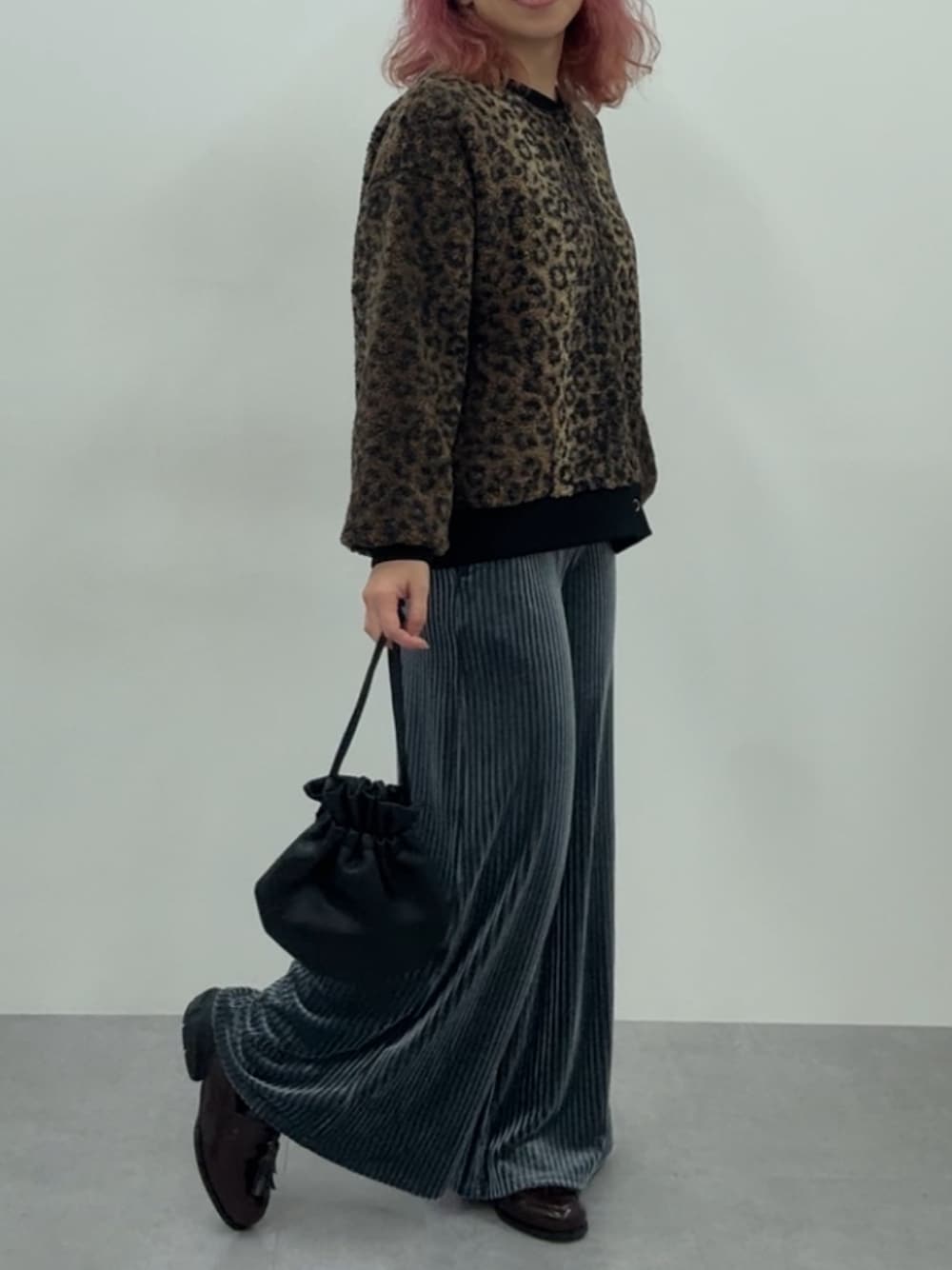 ブルー系のパンツ、ブラウン系のカーディガン/ボレロ、ブラウン系のスニーカーを着用したレディースの秋コーディネートの1枚目の写真