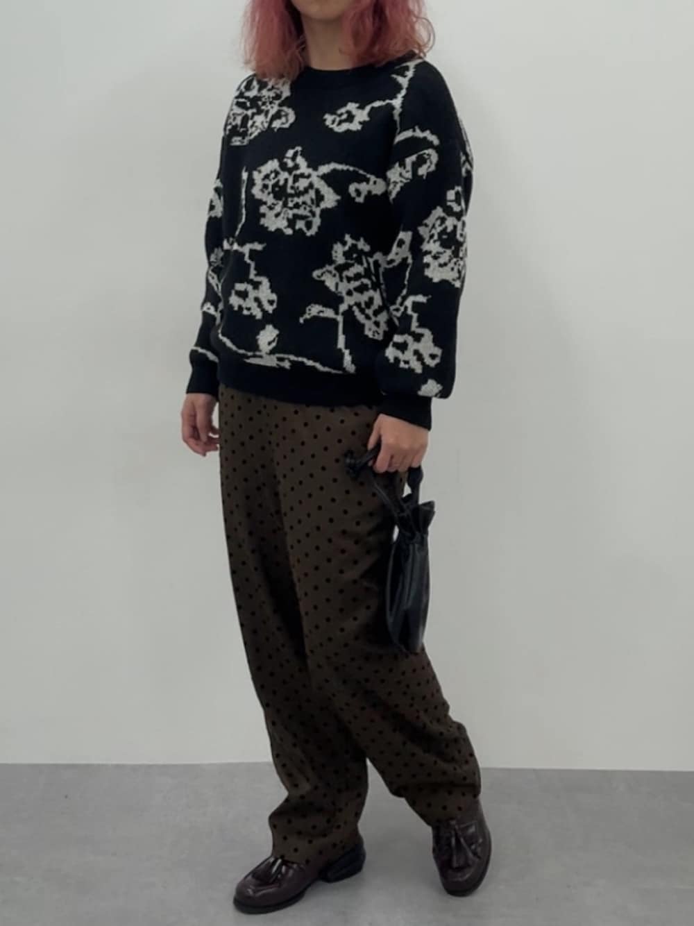 ブラウン系のスニーカー、ブラウン系のパンツ、ブラック系のニット/セーターを着用したレディースの冬コーディネートの1枚目の写真