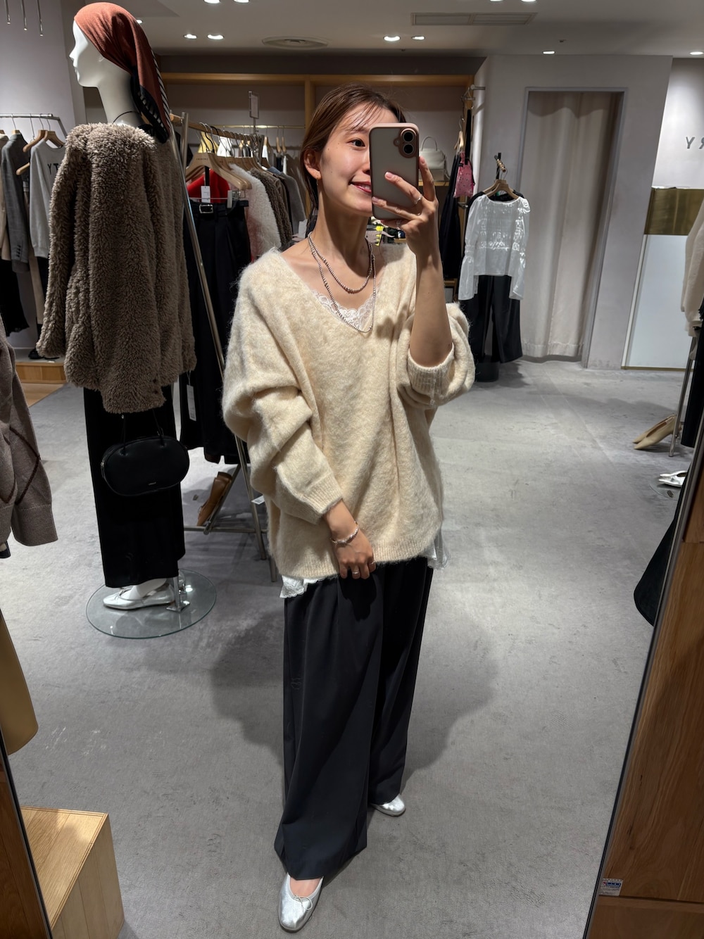 ホワイト系のニット/セーター、ホワイト系のキャミソール、グレー系のスラックスを着用したレディースの秋コーディネートの1枚目の写真