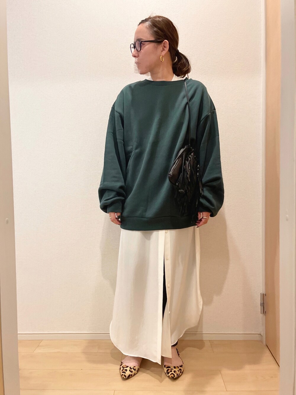 グリーン系のスウェット、ブラック系のバッグ、ホワイト系のシャツワンピースを着用したレディースの秋コーディネートの1枚目の写真