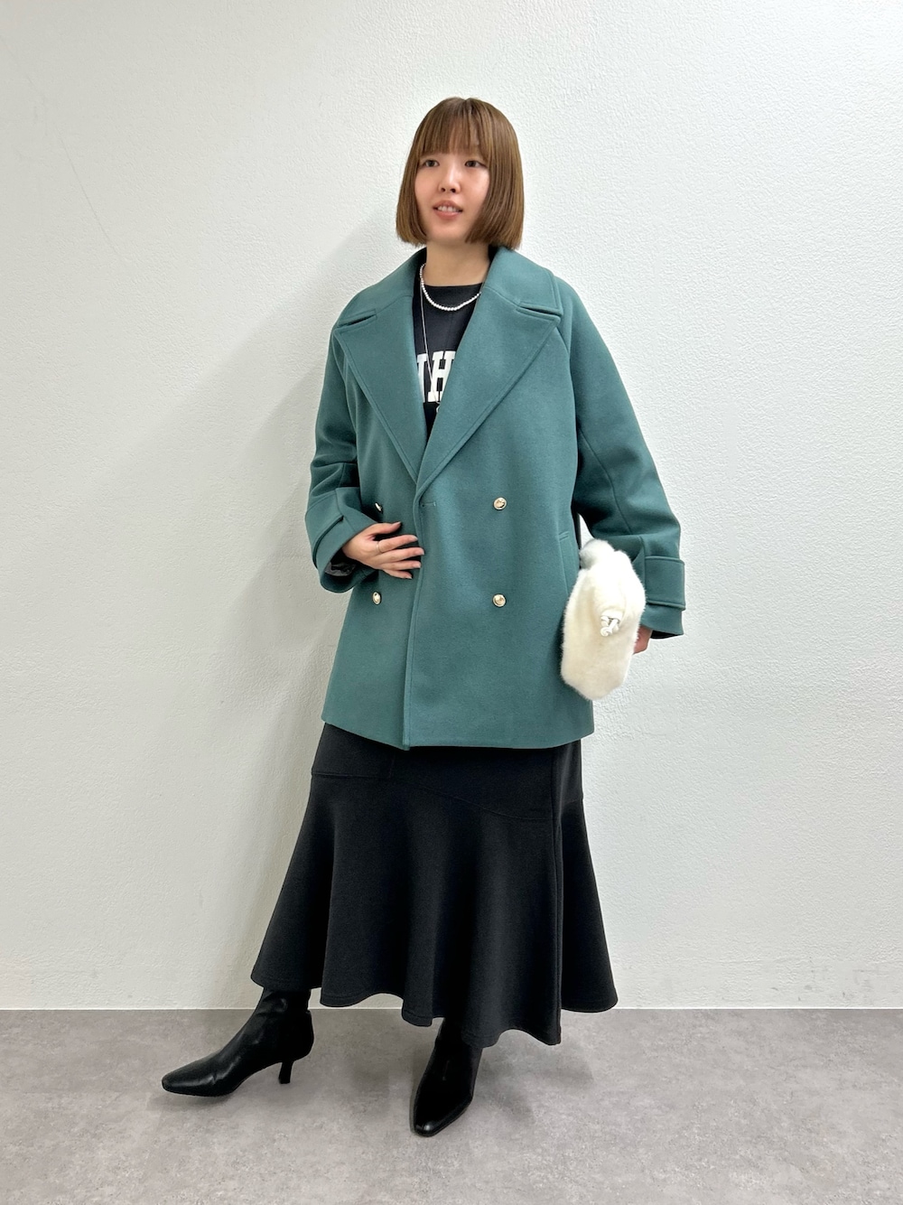 グリーン系のピーコート、グレー系のワンピースを着用したレディースの秋コーディネートの1枚目の写真