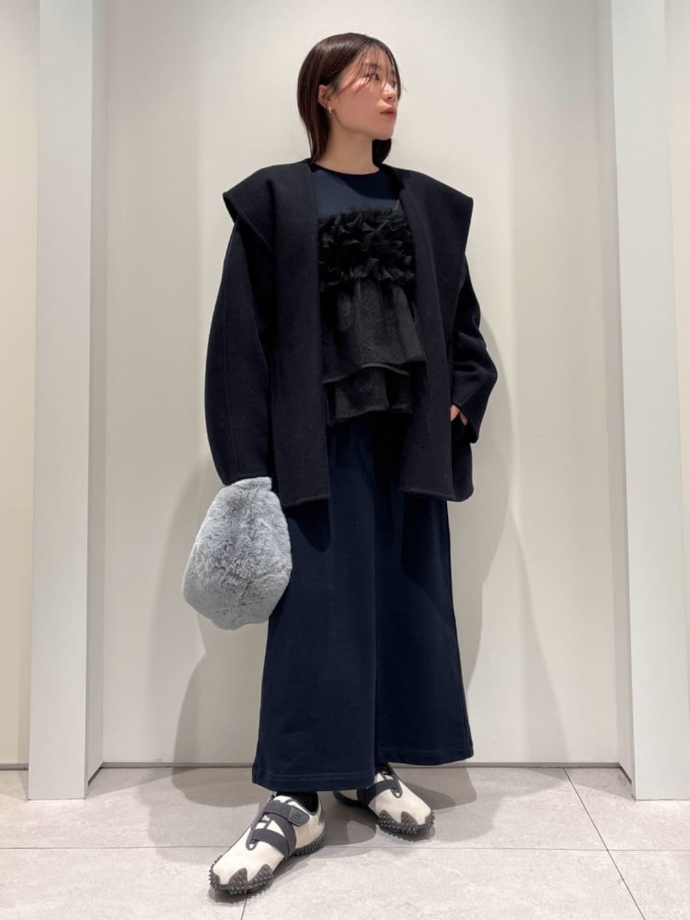 ブルー系のダッフルコート、ブルー系のワンピース、ブルー系のハンドバッグを着用したレディースの冬コーディネートの1枚目の写真