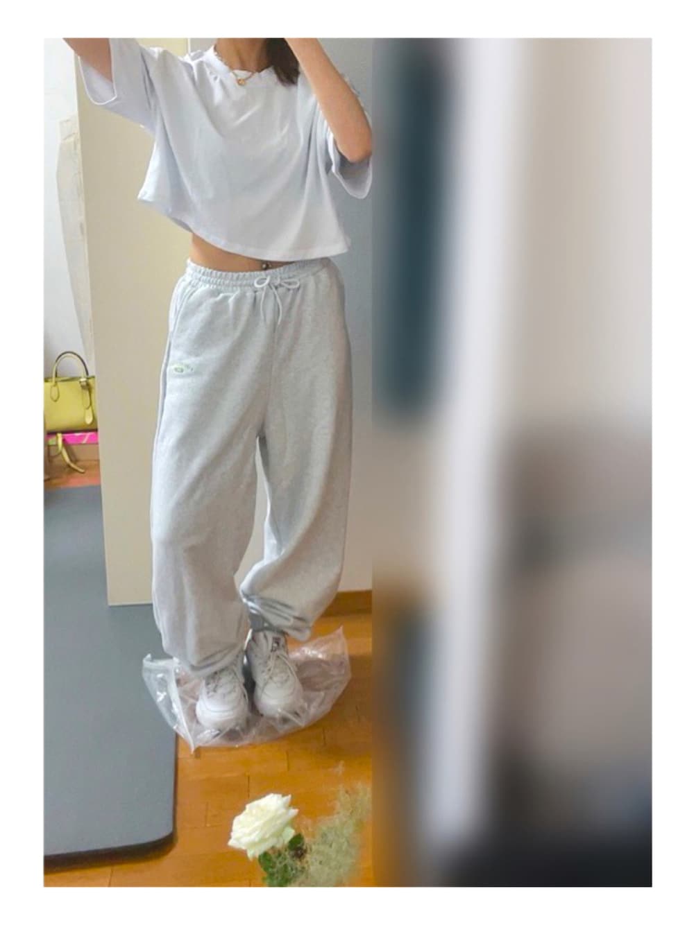 ホワイト系のTシャツ/カットソー、ベージュ系のスウェットパンツ、ホワイト系のスニーカーを着用したレディースの夏コーディネートの1枚目の写真